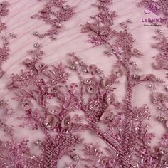 a close up view of the pink and silver beaded fabric on a dress with flowers