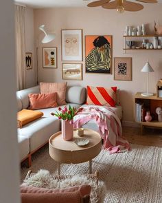 a living room filled with lots of furniture and pictures on the wall above it's coffee table