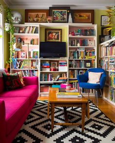 a living room filled with furniture and bookshelves covered in lots of bookcases