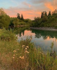 the sun is setting over a small lake