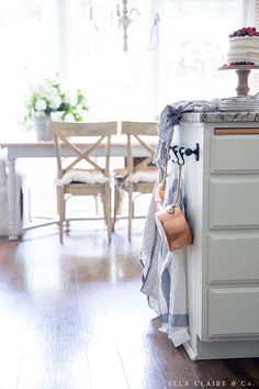 a kitchen with white cabinets and wooden floors