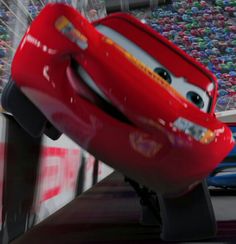 the character from cars is flying through the air in front of a stadium full of people