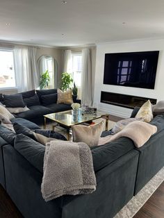 a living room filled with furniture and a flat screen tv mounted on the wall above a fireplace