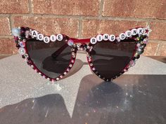 💗Do you know someone at Texas A&M getting ready for their Ring Dunk?  These custom AGGIE RING DUNK cat-eye Sunnies 🕶️ are the perfect accessory for a ring dunk celebration and make a great gift! Enjoy these custom and one-of-a-kind sunglasses that include lots sparkles ✨! I have both maroon sunnies and white sunnies and they can say any combination of words. Each pair of bejeweled beauties comes protected and wrapped tight. All pairs are made by an Aggie Mom whose daughter is entering her Juni Aggie Ring Dunk Party Ideas, Aggie Ring Pictures, Aggie Ring Dunk Pitcher, Ring Day Aggie, White Sunnies, Bedazzled Sunglasses, Aggie Ring Dunk, Ring Dunk, Aggie Ring