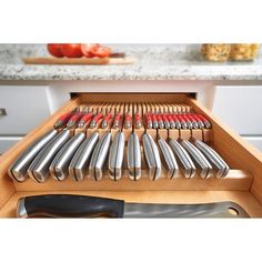 a drawer with knives and other kitchen utensils on it in the middle of a countertop