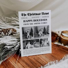 a christmas book sitting on top of a wooden table next to candles and pine cones