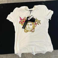 Brand New T Shirt. Versace. New With Tags. Perfect For A Size S / M Designer Graphic Print T-shirt For Spring, Luxury Crew Neck Tops For Spring, Luxury Crew Neck Summer Top, Luxury Summer Crew Neck Tops, Luxury Crew Neck Top For Summer, Luxury Graphic Print Tops For Summer, Designer White T-shirt For Spring, Versace Tops, Versace Top