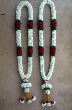 two white and red beaded necklaces with tassels on each strander