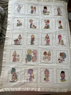 a white quilt with pictures of children on it