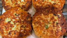 four crab cakes sitting on top of a white plate