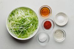 the ingredients for this salad are neatly arranged in separate bowls, including onions and sprouts