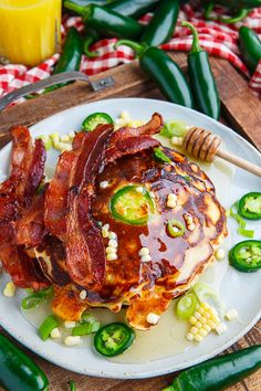 a white plate topped with pancakes covered in bacon and jalapenos