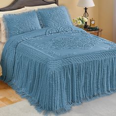 a bed with a blue bedspread and pillows