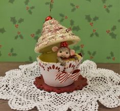 a small toy mouse in a cup on a doily