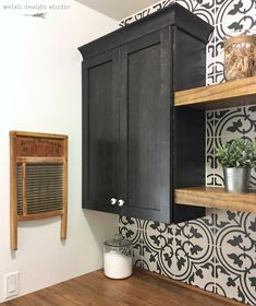 a kitchen with black cabinets and white wallpaper