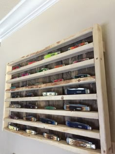 a wooden shelf filled with lots of toy cars