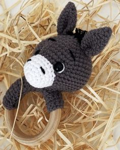 a crocheted donkey ring on top of some dry grass with straw in the background