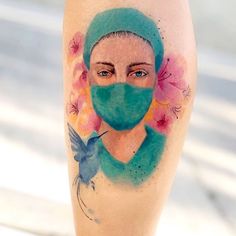 a woman with a face mask and flowers painted on her leg is seen in this artistic photo