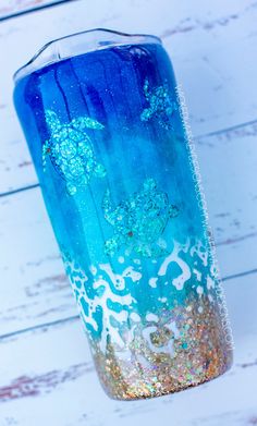 a blue and gold vase sitting on top of a white table