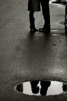 a man and woman standing next to each other in the rain