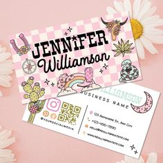 two business cards with stickers on them sitting next to some flowers and daisies