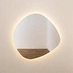 a white wall with a round mirror on it