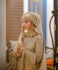 a woman wearing a bridal outfit and jewelry