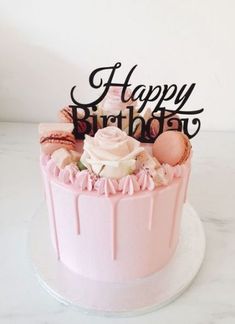 a birthday cake with pink frosting and decorations