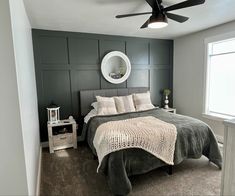 a bedroom with a bed, nightstand and ceiling fan in the middle of the room