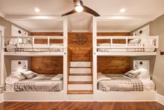 two bunk beds in a room with wooden floors and ceiling fans on either side of them