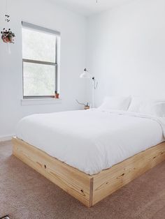 a bed with white sheets and pillows in a room