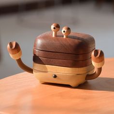 a wooden box with two eyes on it sitting on top of a table