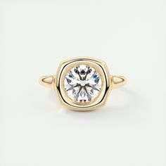 a yellow gold ring with a round brilliant cut diamond in the center, on a white background