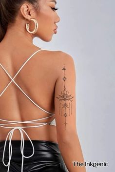 the back of a woman's top with tattoos on her upper half and shoulder