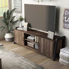 a flat screen tv sitting on top of a wooden entertainment center