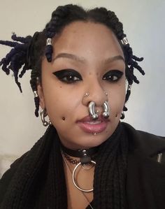 a woman with piercings on her nose and nose ring in front of her face