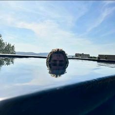 a man with his head sticking out of the top of a swimming pool looking at the camera