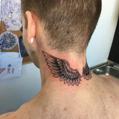 a man with a tattoo on his neck that has an angel wing design on it