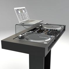 a laptop computer sitting on top of a dj's table with turntables