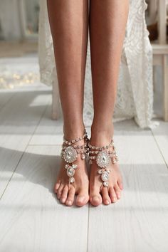 the legs and ankles of a woman wearing barefoot sandals are adorned with jewels, beads and pearls