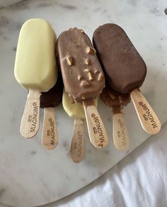 three ice creams with wooden spoons on a marble counter