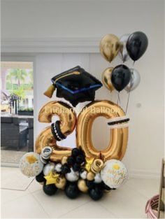 the balloon number 50 is decorated with black, gold and silver balloons that spell it's graduation