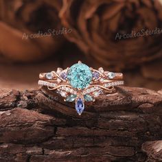 a blue diamond ring sitting on top of a piece of wood