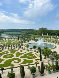 an elaborate garden with water fountain surrounded by trees