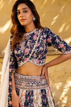 This ensemble is the perfect choice for anyone who wants to make a statement at their next special occasion.
Crafted from high-quality georgette crepe fabric, this lehenga set features a stunning combination of navy blue and off-white hues that create a striking contrast. The embellished belt adds a touch of luxury to the ensemble, drawing attention to your waistline and creating a flattering silhouette.
The set comes with a matching hand-embroidered blouse that complements the lehenga perfectly Blue Georgette Choli With Floral Embroidery, Semi-stitched Blue Pre-draped Saree With Floral Embroidery, Blue Partially Stitched Pre-draped Saree With Floral Embroidery, Cut Work Blouse, Embellished Belt, Embroidered Lehenga, Hem Blouse, Organza Dupatta, Work Blouse