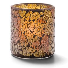 a candle holder made out of glass and wood with yellow, brown and orange designs on it