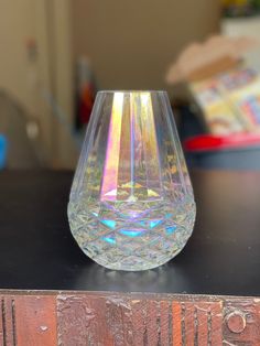 a clear glass sitting on top of a wooden table next to a pile of books