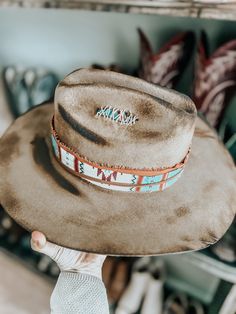 This burnt, distressed, felt fedora hat is a size 22 1/2 inches around.The hat band is an aztec and genuine leather band with a leather feather accent as well as a real feather and playing cards. This hat is burnt so it might have a slight smell for a few weeks.All feathers are glued to hold on the hat.FREE SHIPPING ON ALL OUR HAT ORDERS!All hats are branded by ©The Kiersten Zile CollectionNeed a Custom order? Message the Shop and we can start on that for you! Leather Flat Brim Fedora For Festivals, Rustic Leather Hats For Festival, Artisan Leather Hat For Rodeo, Bohemian Leather Hat Bands For Festivals, Leather Bohemian Hats For Festivals, Bohemian Leather Hat For Western-themed Events, Bohemian Leather Hats For Country Events, Leather Bohemian Hat For Western-themed Events, Bohemian Distressed Adjustable Hat Bands