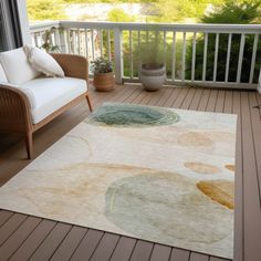 a large rug on a wooden deck near a couch and chair with potted plants