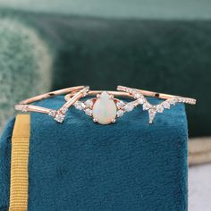 an opal and diamond ring sits on top of a blue velvet bag